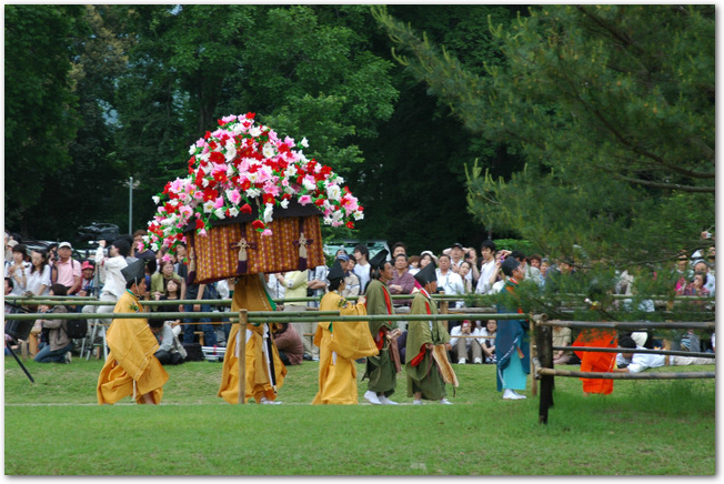 葵祭の行列で花笠を持った人が通っていく様子