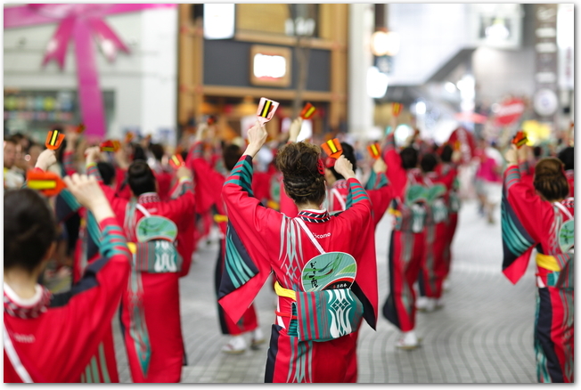 YOSAKOIソーラン祭りで鳴子を手にして踊る女性の踊り子たち