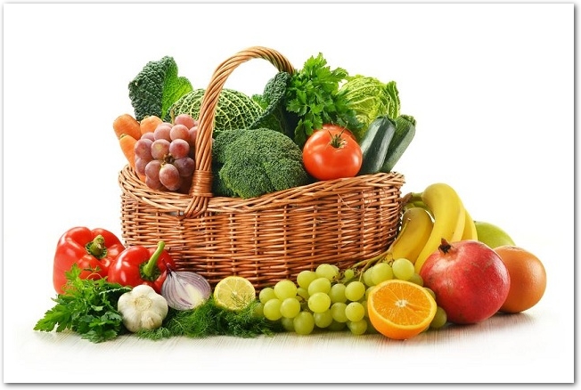 野菜が盛られた木のバスケットの周りに果物が置いてある様子